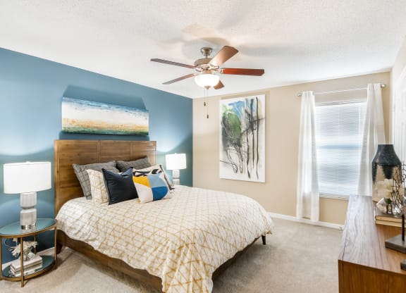 a bedroom with a bed and a ceiling fan at Crossgates Apartment Homes, Starkville, Mississippi
