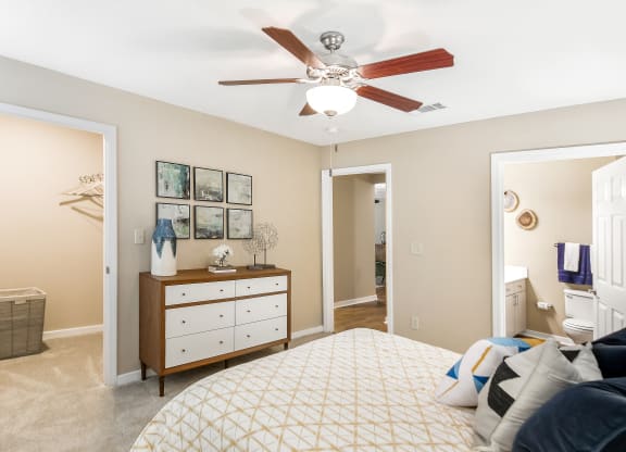 a bedroom with a large bed and a ceiling fan at Crossgates Apartment Homes, Starkville, MS 39759