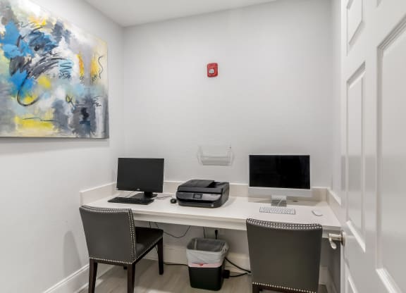 a room with a desk with two computers and a printer at Avalon Apartment Homes in Mississippi 39759