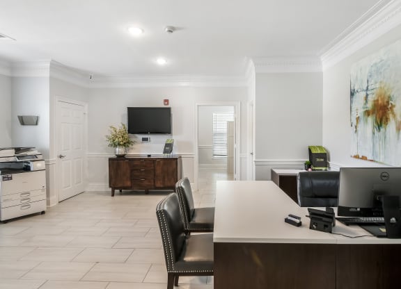 an office with a desk and a computer and a television at Avalon Apartment Homes in Starkville, 39759