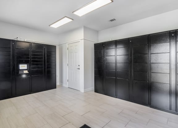 a row of black lockers in a room with a white door at Avalon Apartment Homes in Starkville, MS 39759