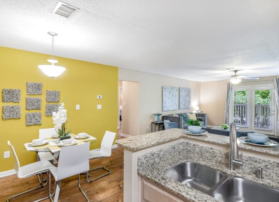 an open kitchen and dining room with a table and chairs at Avalon Apartment Homes in Starkville, Mississippi 39759