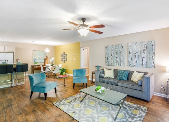 a living room with a couch and a ceiling fan at Avalon Apartment Homes in Starkville, MS 39759