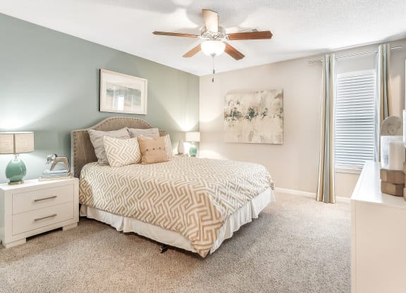 a bedroom with a bed and a ceiling fan at Avalon Apartments Starkville, MS