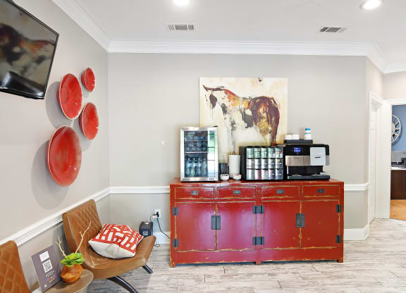 a living room with a red credenza and a coffee machine on top of it at Lexington Pointe Apartment Homes in Oxford, Mississippi