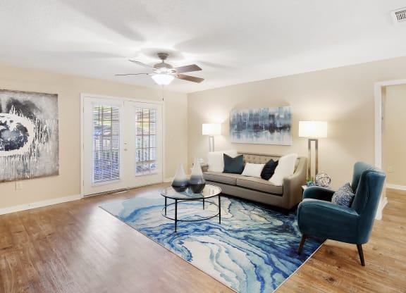a living room with a couch and a chair and a ceiling fan at Lexington Pointe Apartment Homes in Oxford, Mississippi