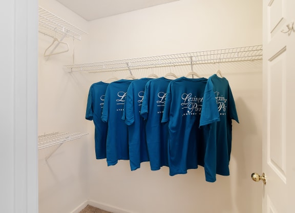 a walk in closet with shirts hanging on a rack at Lexington Pointe Apartment Homes in Oxford, MS 