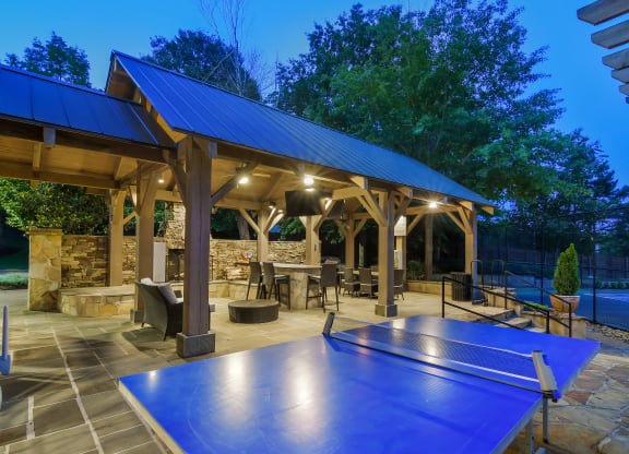 a backyard with a ping pong table and a pavilion with a pool at Lexington Pointe Apartment Homes in Oxford, 38655