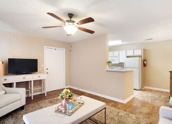 a living room with a ceiling fan    and a kitchen at Parklane Apartment Homes, McComb