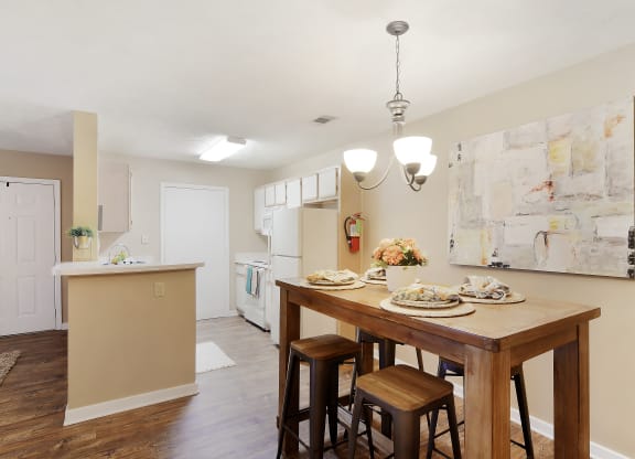 a kitchen and dining room with a wooden table and chairs at Parklane Apartment Homes, McComb