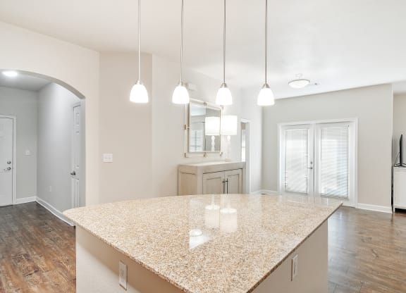 Open kitchen and living room with a marble counter top at Faulkner Flats Apartment Homes, Oxford, 38655