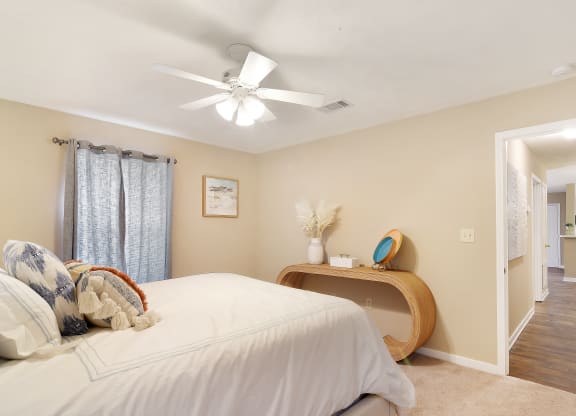 a bedroom with a large bed and a ceiling fan at Parklane Apartment Homes, Mississippi