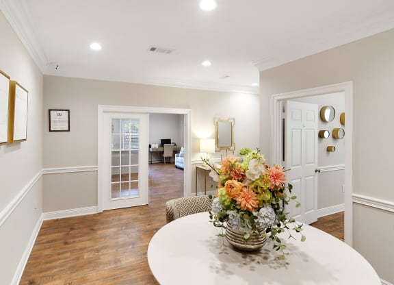 a dining room with a table and a vase with flowers at Parklane Apartment Homes, Mississippi, 39648
