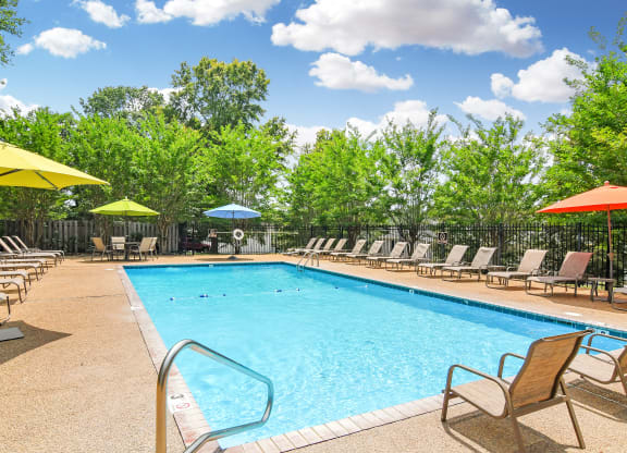 our resort style pool is filled with chairs and umbrellas at Parklane Apartment Homes, Mississippi