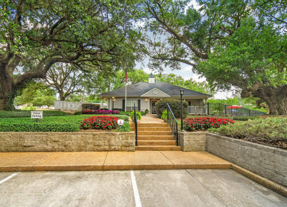 the front of a house with stairs and a stone wall and trees at Parklane Apartment Homes, McComb, 39648