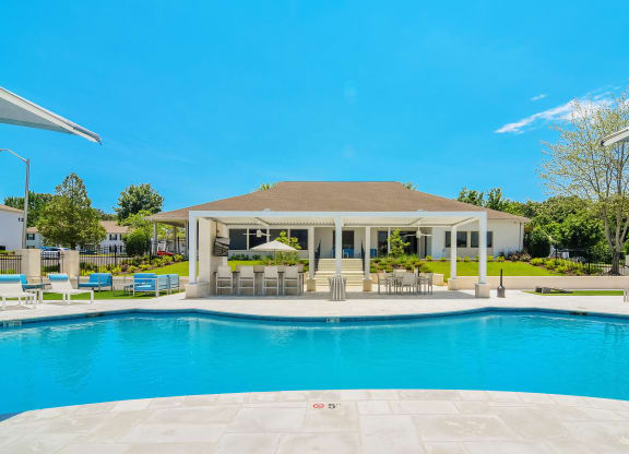 a swimming pool with a house in the background at The Vineyard of Olive Branch Apartment Homes, Olive Branch