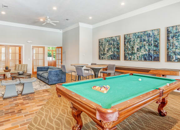 a game room with a pool table and chairs at The Vineyard of Olive Branch Apartment Homes, Mississippi