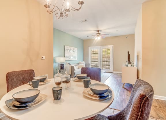 a dining room with a table and chairs and a ceiling fan at The Vineyard of Olive Branch Apartment Homes, Mississippi 38654