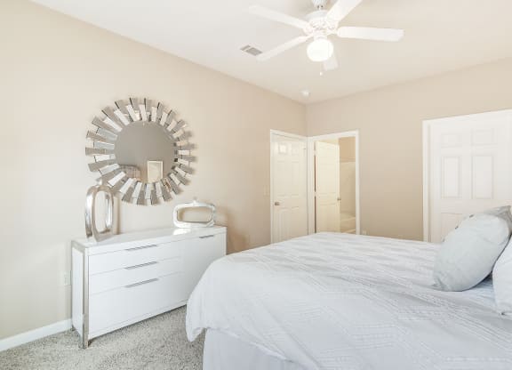 a white bedroom with a bed and a mirror at The Vineyard of Olive Branch Apartment Homes, Olive Branch, MS, 38654