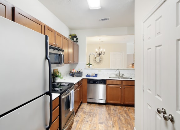 a kitchen with stainless steel appliances and wooden cabinets at Landing Willow Bayou in Bossier City, Louisiana