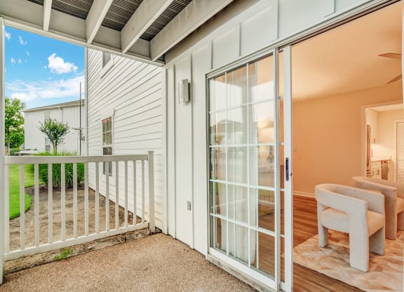 a living room with glass doors and a balcony at The Oliver Apartment Homes in Olive Branch, MS 