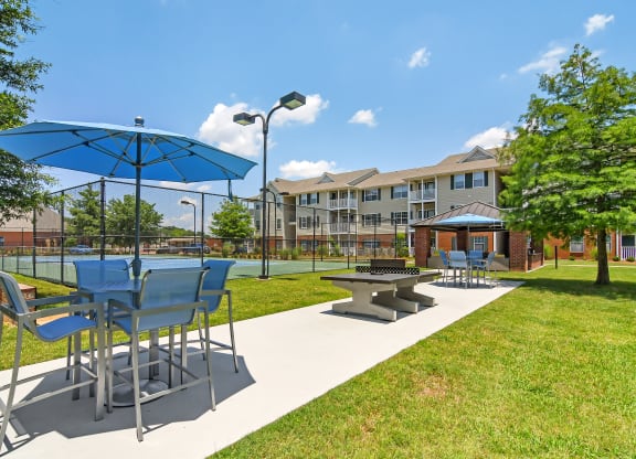community picnic area with tables and umbrellas at The Madison Apartment Homes in Tyler, Texas