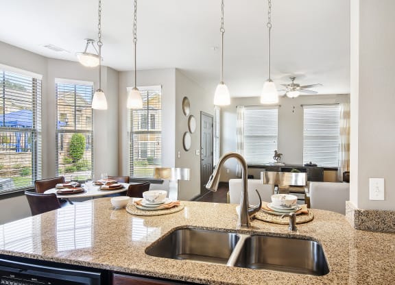 an open kitchen and living room with a sink and a counter top at Wellington Grande Apartment Homes, Longview