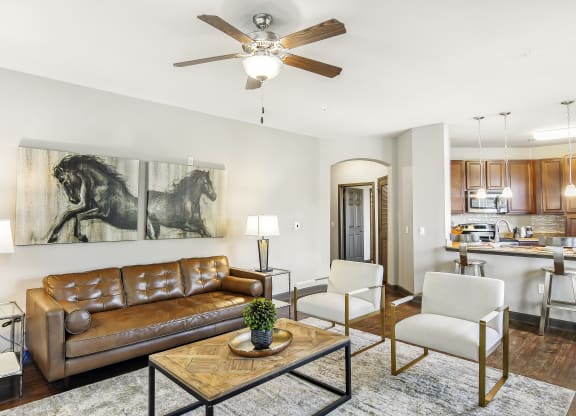 a living room with a ceiling fan and a couch at Wellington Grande Apartment Homes, Longview, Texas