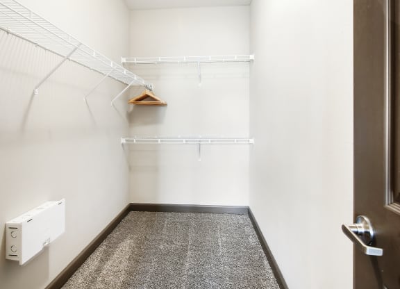 a walk in closet with white walls and a white dryer in it at Wellington Grande Apartment Homes, Longview, TX, Texas, 75605