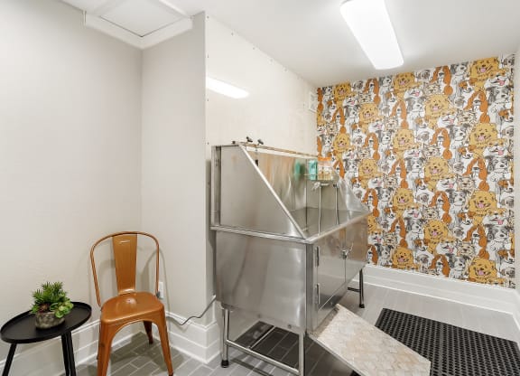 a small kitchen with a stainless steel refrigerator and two chairs at Lagniappe of Biloxi Apartment Homes, Mississippi   , 39532