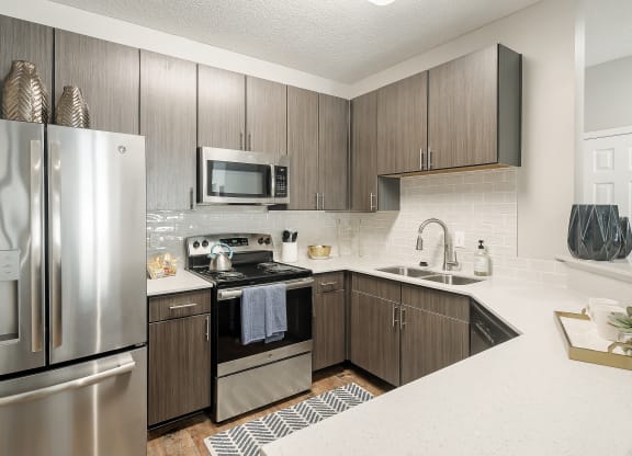 our spacious kitchen is equipped with stainless steel appliances and a white counter top at Lagniappe of Biloxi Apartment Homes, Biloxi
