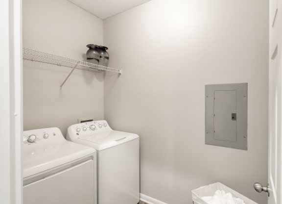a white washer and dryer in a white laundry room at Lagniappe of Biloxi Apartment Homes, Biloxi