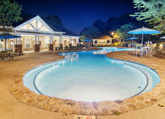 Cool pool with chairs and umbrellas at night at the resort at Highlands Apartment Homes, Tennessee