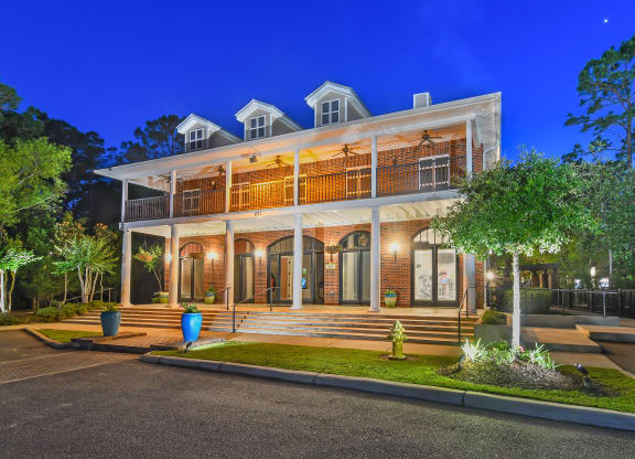a house with a large porch and a tree in front of it at Lagniappe of Biloxi Apartment Homes, Mississippi