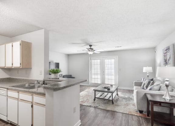a kitchen and living room with a ceiling fan and at The Pointe Apartment Homes in MS 39553