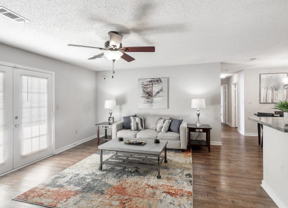 a living room with a couch and a ceiling fan at The Pointe Apartment Homes in Gautier, MS 