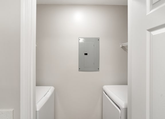 a white laundry room with a white washer and dryer at The Woodlands Apartment Homes, Meridian, MS, 39301