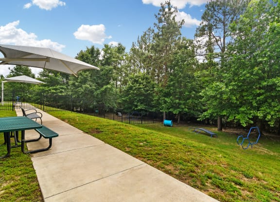 a picnic area with a picnic table and benches in a parka picnic area with a picnic table and benches in a parka picnic area with a picnic table and benches in a park at Charleston Apartment Homes, Mob