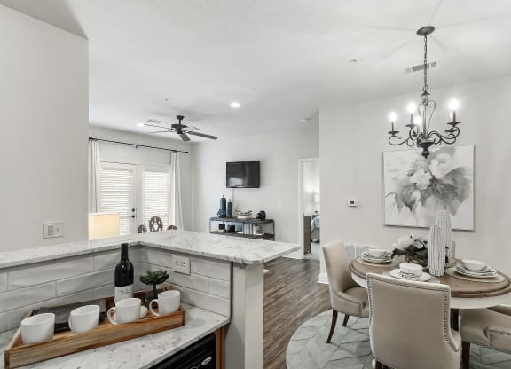 an open kitchen and dining area with a dining table and chairs at Charleston Apartment Homes, Mobile