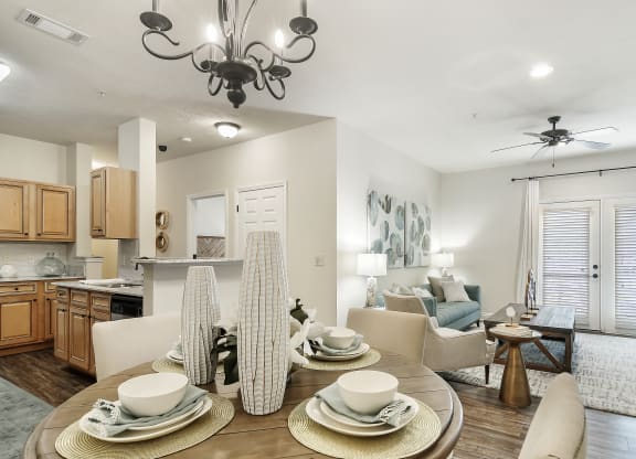 an open living room and kitchen with a dining room table at Charleston Apartment Homes, Mobile, Alabama