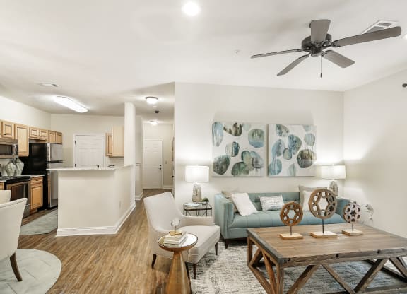 an open living room and kitchen with a ceiling fan at Charleston Apartment Homes, Alabama 36695