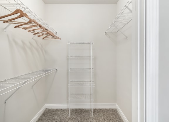 a walk in closet with white walls and a wire closet organizer at Charleston Apartment Homes, Mobile, AL 36695