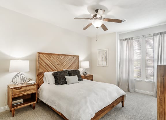 a bedroom with a bed and a ceiling fan at Charleston Apartment Homes, Alabama