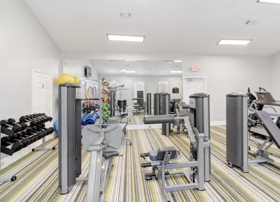 a gym with cardio machines and weights on the floor at Summit of Shreveport Apartments, Louisiana