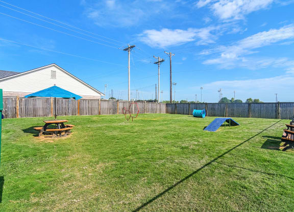 a yard with a picnic table and a house with a fence at Summit of Shreveport Apartments, Louisiana 71105