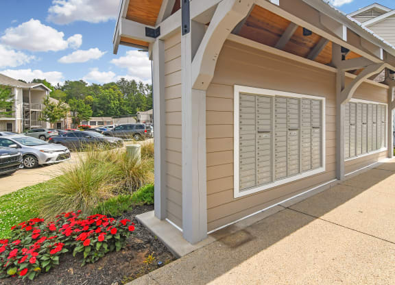 a side view of a building with a sidewalk and flowers at Parkwest Apartment Homes, Hattiesburg