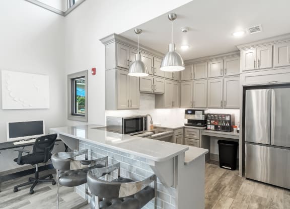 a white kitchen with a large island and stainless steel appliances at Parkwest Apartment Homes, Hattiesburg, 39402
