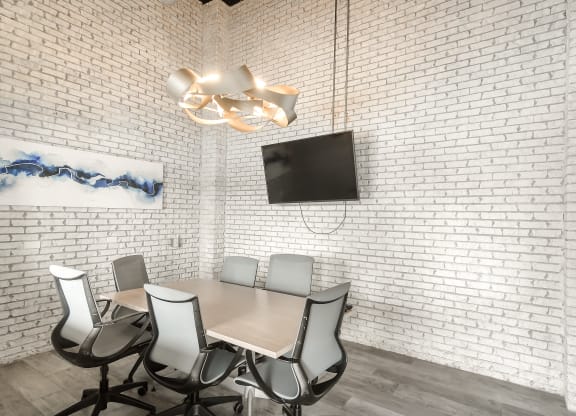a conference room with a table and chairs and a tv on the wall at Parkwest Apartment Homes, Hattiesburg, MS