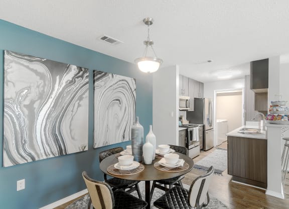a dining room and kitchen with a table and chairs at Parkwest Apartment Homes, Hattiesburg, MS