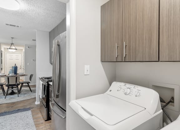 a utility room with a washer and dryer and a kitchen with a sink at Parkwest Apartment Homes, Hattiesburg, MS, 39402
